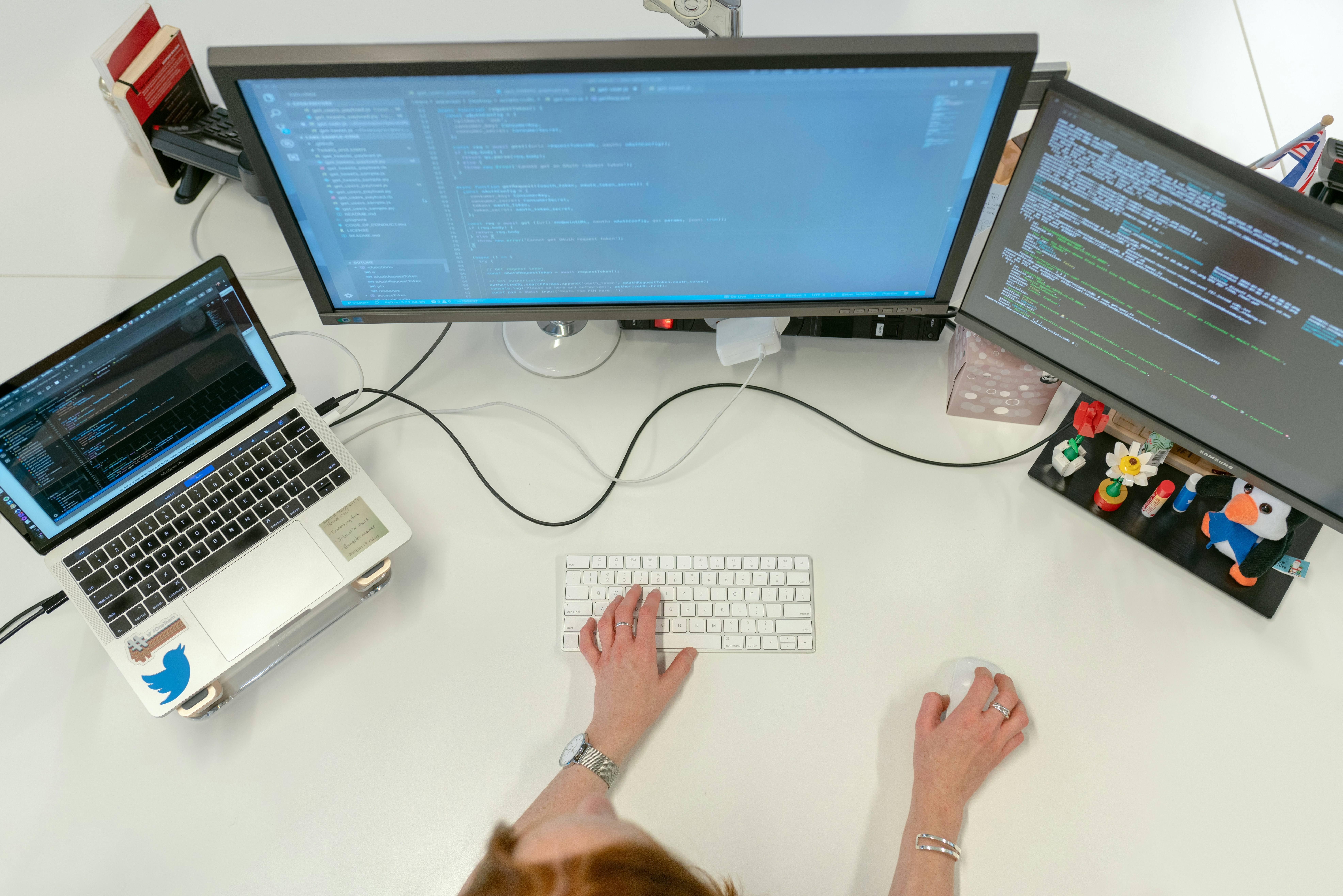 Developer working on automation code at desk with multiple monitors