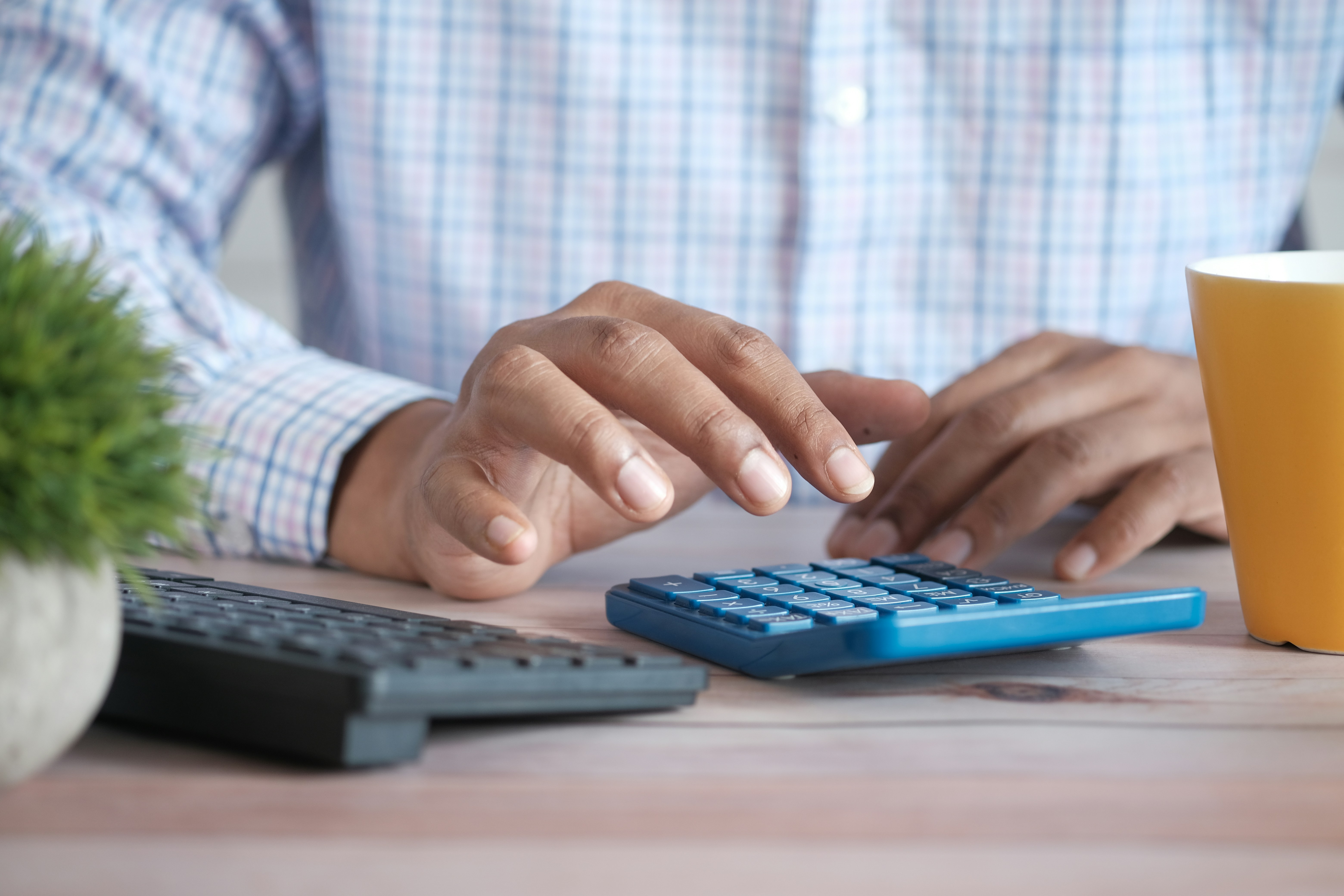 Person using calculator for ROI analysis